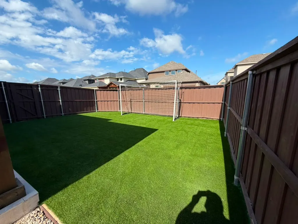 Artificial turf play yard enclosed by a privacy fence