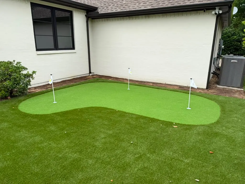 Backyard artificial turf putting green with three practice flags
