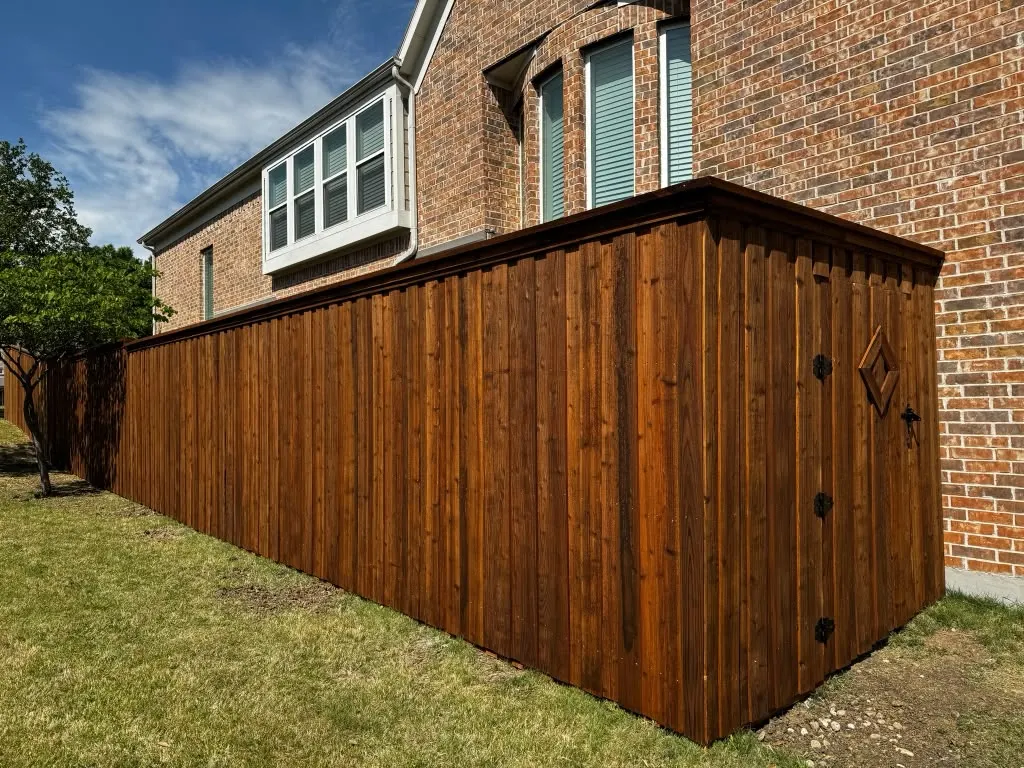 Cedar privacy fence joined to a matching utility enclosure