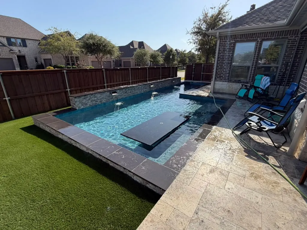 Modern rectangular swimming pool with integrated spa and artificial turf